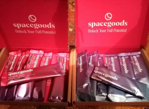Customer's two open boxes displaying Rainbow Dust and Astro Dust supplement sachets from Spacegoods.