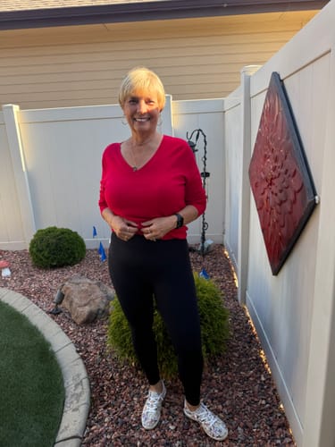 Customer wearing black 3D Anti-Cellulite Leggings and a red top, showing the front fit outdoors.