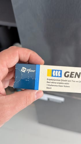 A customer's hand holding the Pfizer Genotropin box, showing the blue and white packaging.