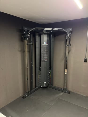 Rezensent zeigt die fertig aufgebaute schwarze X-Five Kabelzugstation in der Ecke eines Raumes.
