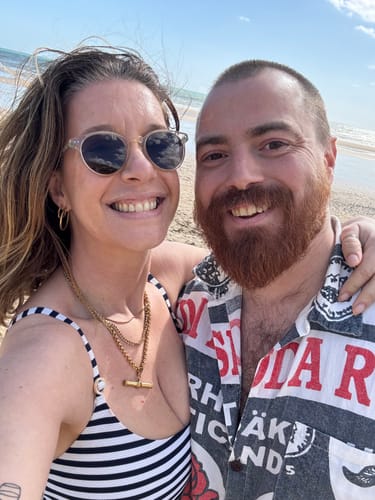 Customer wearing her XL T-Bar Necklace layered with another gold chain at the beach.