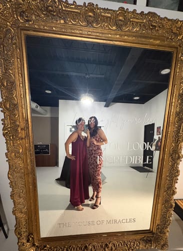 Reviewer in a mirror selfie wearing the full-length burgundy Audrey Satin Jumpsuit.