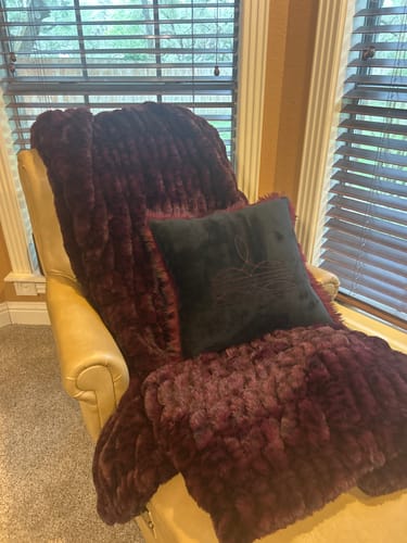 Customer's black Boot Stitch Pillow showing its stitched pattern on a chaise lounge.
