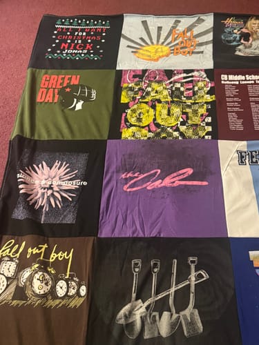 Close-up of a customer's Project Repat T-Shirt Quilt, showing various band t-shirts like Fall Out Boy and Green Day.