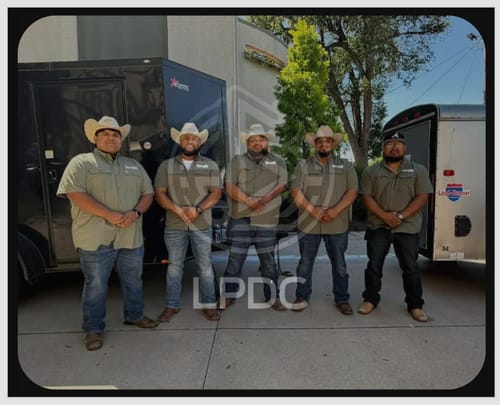 Five customers wearing matching green Creekbed Short Sleeve Shirts as team uniforms outdoors.
