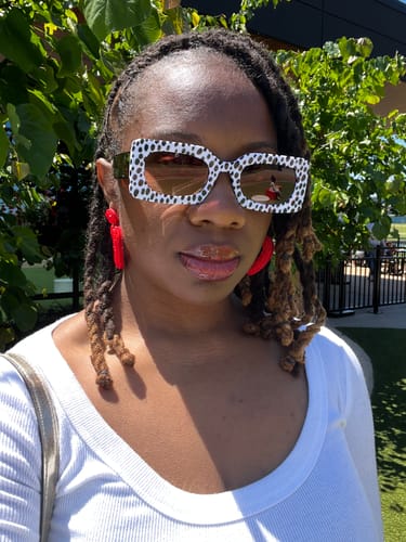 Reviewer wearing the stylish Spot Me If You Can Mixed Print Sunglasses outdoors on a sunny day.