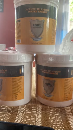 Cliente muestra tres botes apilados del Sellador Líquido Impermeabilizante Leisel.