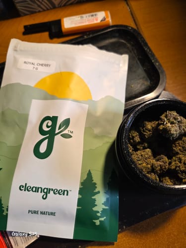 Customer's Royal Cherry pouch next to an open container filled with the dark cannabis buds.