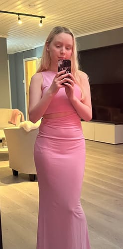 Reviewer taking a mirror selfie in the body-skimming Rosy Pink Goddess Dress, showing the waist cut-out.