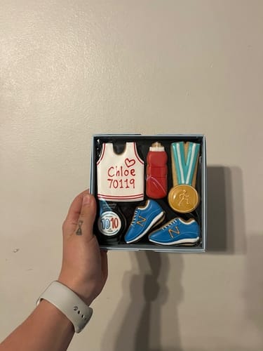 Customer holding the personalized Running Biscuit Box with a vest biscuit for 'Chloe'.