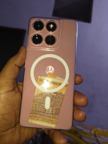 Customer holding their pink phone in the Anti Yellow Magsafe Clear Case, showing a banknote inside.