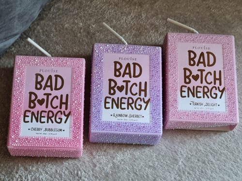 Customer's three glittery juice-box packages for the Manifest Crystal Bad Bitch Energy Lip Trio in pink, purple, and light pink.