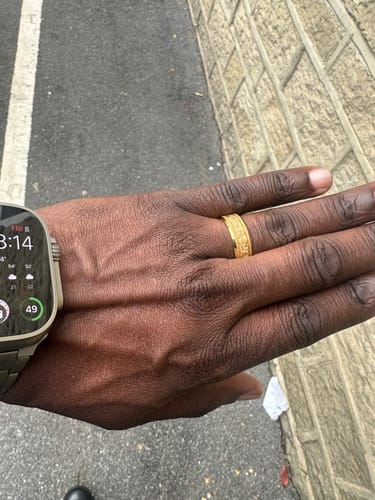 Customer's hand showing the textured gold Aureum ring outdoors.