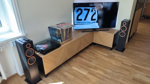 Customer's black TT-3 record player on a wooden media console with speakers and vinyl records.