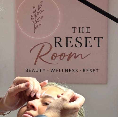 A customer receiving a professional brow shaping treatment from a technician in a salon.