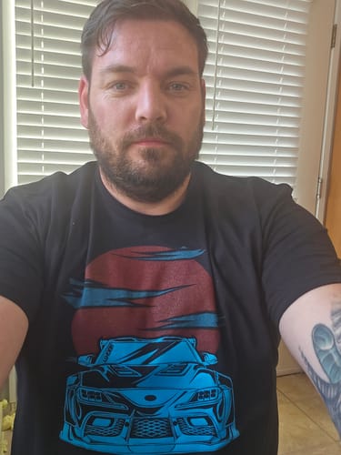 Customer wearing the 80Eighty® Solar Drift Shirt, showing the fit and graphic of a blue car against a red sun.