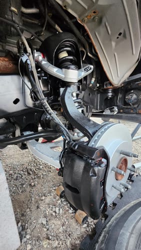 Reviewer's silver Aluminum Forged Upper Control Arm installed on a truck's front suspension system.