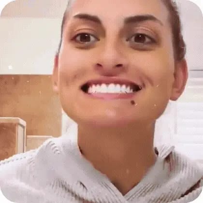 Clienta sonriendo para mostrar sus dientes blancos después de usar el Gel Blanqueador Dental.
