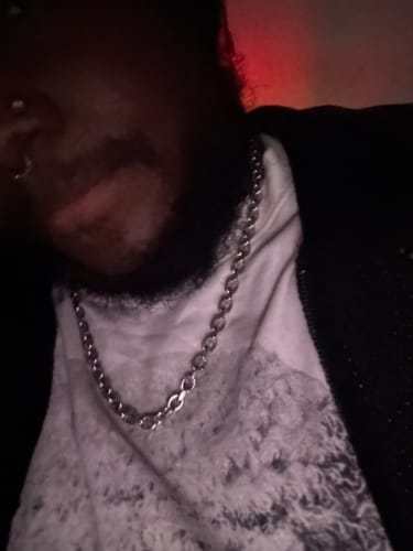 Close-up: A reviewer wearing the silver Aries Chain around their neck over a t-shirt.