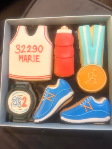 Customer's Running Biscuit Box showing personalized biscuits, including a vest with the name 'MARIE' and the number 32290.
