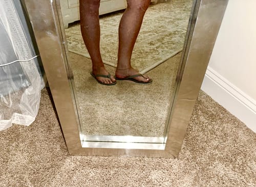 Reviewer wearing the dark Hari Mari Fields Flip Flop Sandals while standing indoors.
