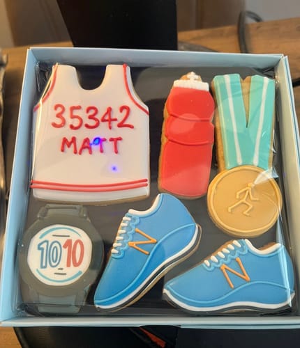 Customer's personalized Running Biscuit Box showing a vest with a race number, trainers, and medal biscuits.