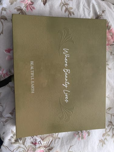 Customer's decorative green Spring Box Packaging shown closed on a floral surface.