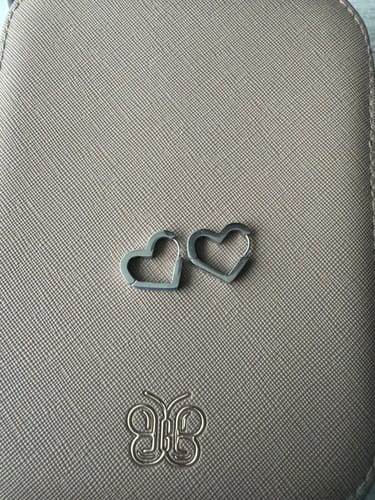 Customer's Mary Heart Silver Hoop Earrings resting on a textured surface.