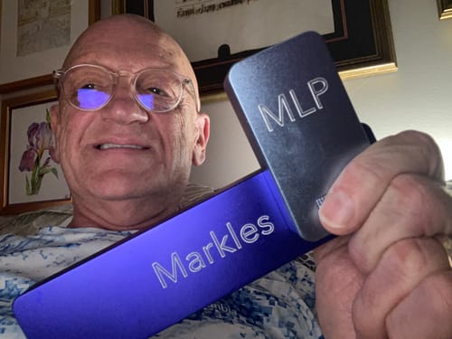 Reviewer holding a personalized silver metal pill case and a purple metal pill case from the 2-pack bundle.