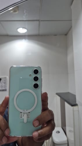 Reviewer's hand holding a Samsung phone, showing the fit of the clear Magsafe case and its white ring.