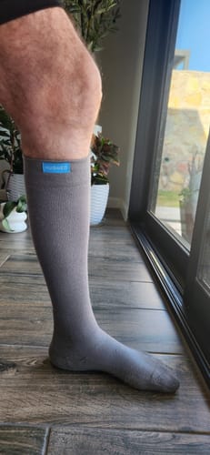 Reviewer's leg shown from the side, wearing a grey Eucalyptus Lyocell Compression Sock.
