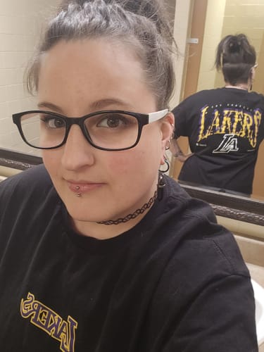 Customer wearing the black SUGA x NBA Lakers Glitch T-shirt, showing the back design in a mirror's reflection.
