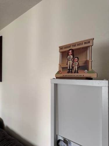 Customer's personalized wooden baseball dugout plaque displayed on a white shelf in their home.