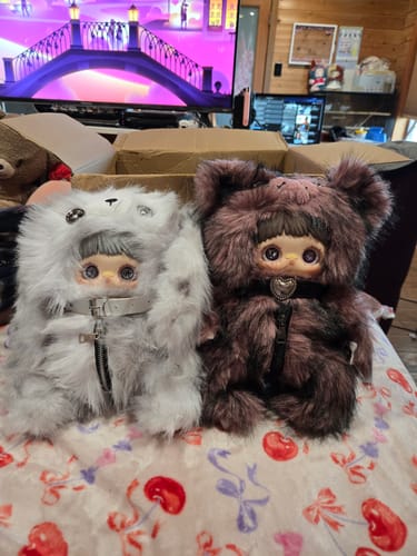 Reviewer's two fluffy MayMei Rebel Doll Backpacks, one white and grey and one dark brown, sitting side-by-side.
