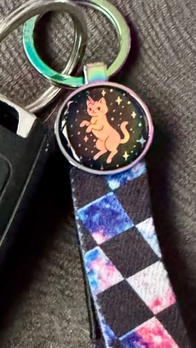 Close-up of a customer's Caticorn Energy Zoxlox keychain showing its holographic charm and iridescent key ring.