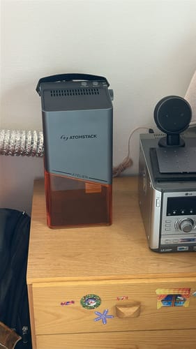 Reviewer's AtomStack Atelier laser engraver set up on a wooden desk.