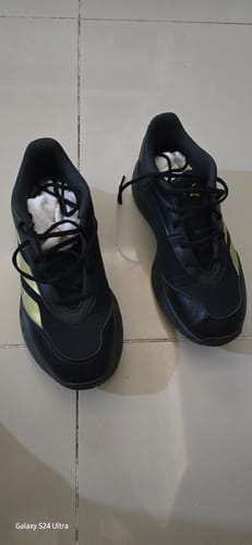 Customer's adidas GAMECHASER Basketball Shoes in a black and gold colorway on a floor.
