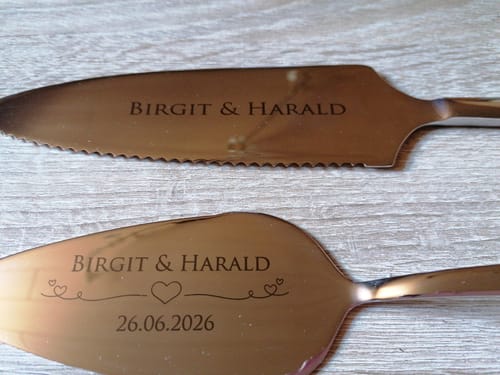 Kunde zeigt sein graviertes Tortenbesteck-Set mit den Namen 'Birgit & Harald' und dem Datum 26.06.2026.