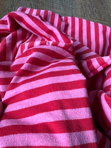 Kundenfoto zeigt eine Nahaufnahme des fusseligen, rot und pink gestreiften SOUL STRIPES Pullovers.