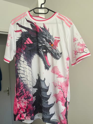 Client montrant le devant du magnifique maillot blanc Japon spécial dragon accroché à un cintre.