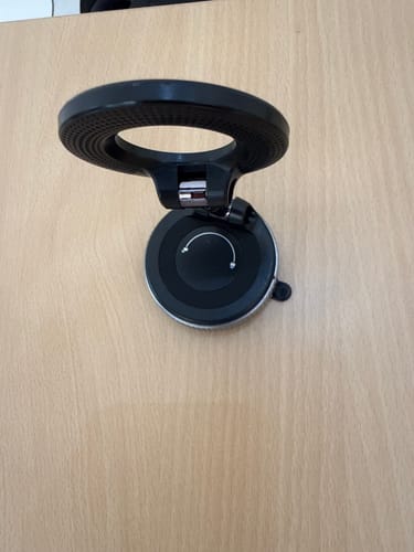 Reviewer's black 360° MagPro Magnetic Phone Holder by Casence resting on a wooden surface.