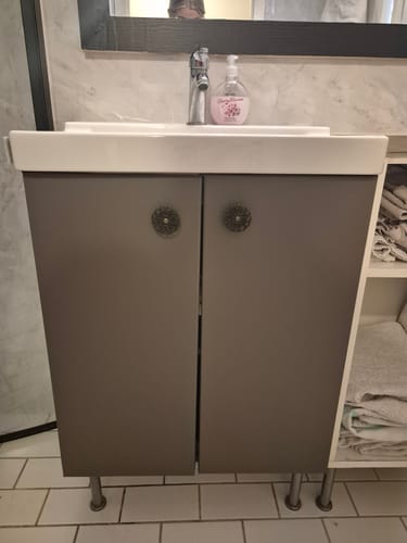 Kunde viser frem et servantskap dekket med matt, taupefarget kontaktplast.