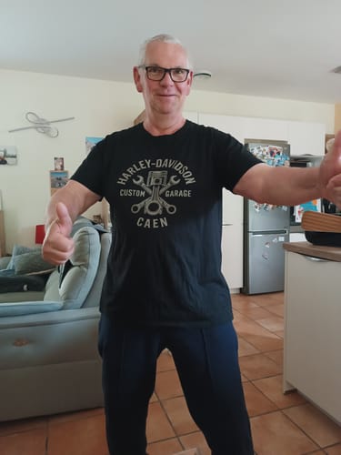 Un client satisfait portant le T-shirt Custom Garage noir, faisant un signe 'pouce en l'air'.