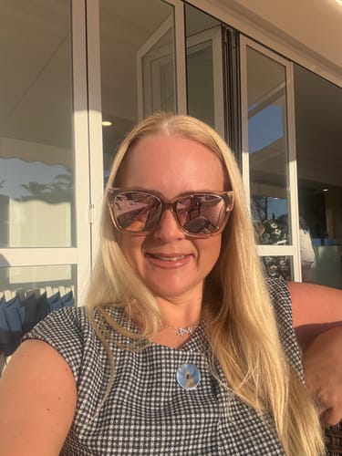 Reviewer smiling outdoors while wearing the oversized Polarized Fit Over Sunglasses.