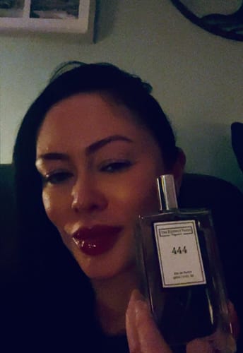 Customer taking a selfie holding their bottle of 'Inspired by Lost Cherry - 444' perfume.