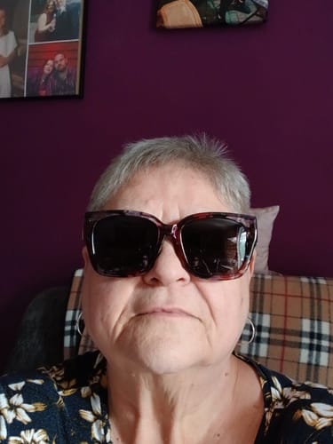 A reviewer's close-up wearing the floral frame Polarized Fit Over Sunglasses.