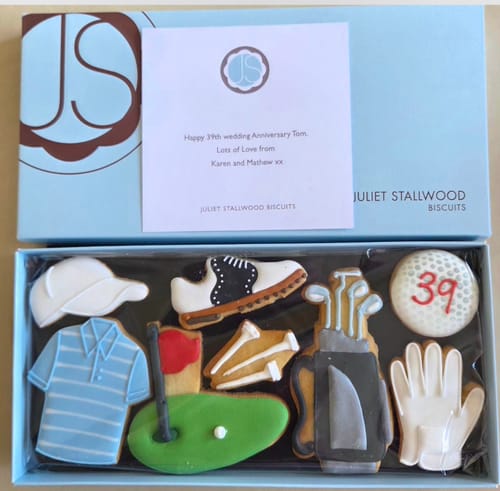 Customer's Golf Deluxe Biscuit Box showing assorted decorated biscuits and a personalized anniversary note.