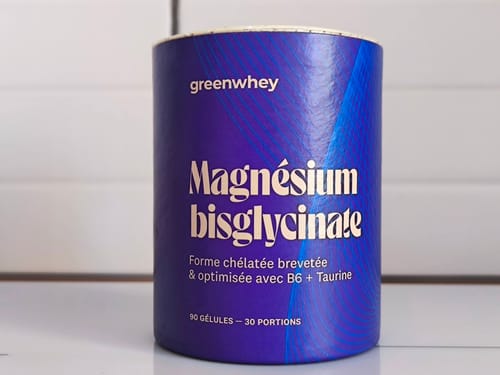 Un client montre le pot de Magnésium Bisglycinate avec son emballage violet et bleu.