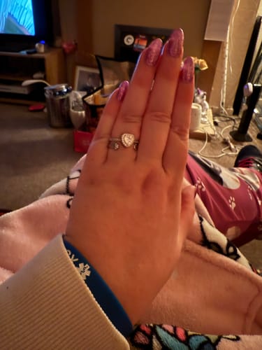 A reviewer's hand wearing the heart-shaped Forever In My Heart Urn Ring on their finger.