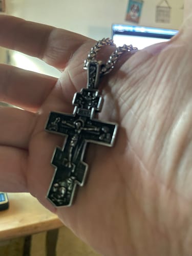 Customer holding the large Titanium Orthodox Jesus Crucifix Necklace in their hand to show its size and detail.